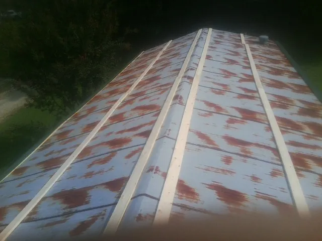Rusted metal roof panels with new wood purlins before replacement — Storm Damage Roof Repair in Cunningham by Roofing Brothers